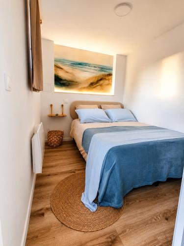 a bedroom with a bed and a painting on the wall at Cocon avec terrasse proche plages et centre in Dives-sur-Mer