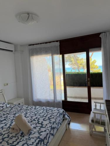 a bedroom with a bed and a large window at Passeig Maritim in Miami Platja
