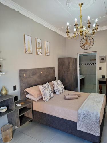 a bedroom with a large bed and a chandelier at 21on2nd Avenue in Tzaneen