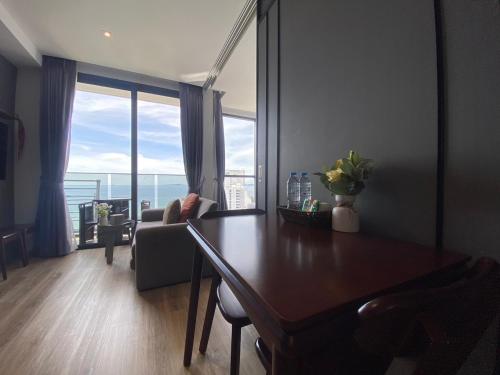 a living room with a table and a large window at Breath Taking View, Amazing Sea View Room in Pattaya South