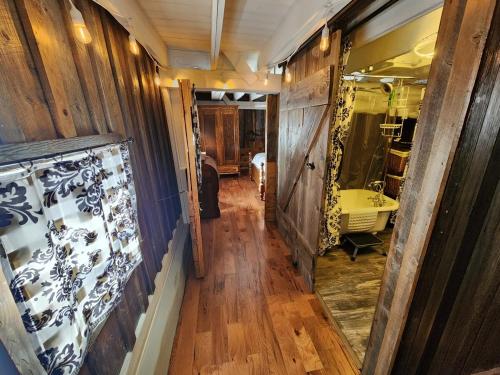 a hallway with a room with wooden walls and a mirror at The Stable at Windmill Ridge Farm in Fredonia