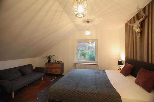 a bedroom with a large bed and a couch at Blackhillhouse - Moderne Auszeit im Harz in Osterode