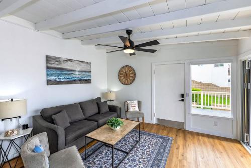 a living room with a couch and a ceiling fan at Steps to the pier! in San Clemente