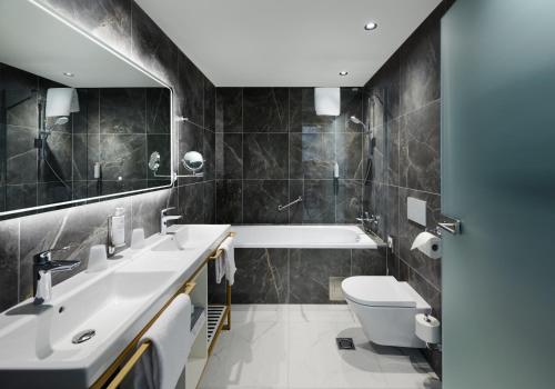 a bathroom with a sink and a toilet and a tub at SOPHIA PALACE Hotel Budapest in Budapest