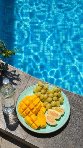 a plate of fruit on a table next to a swimming pool at WesamFarm in Amman