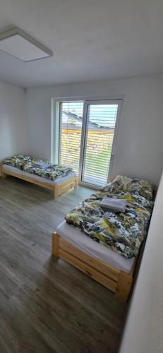 two beds in a room with a window at Útulný klidny pokoj A in Radošovice