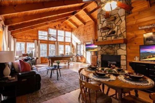 a living room with a table and a fireplace at Cozy Cabin Retreat Near Helen Hot Tub Fireplace in Sautee Nacoochee