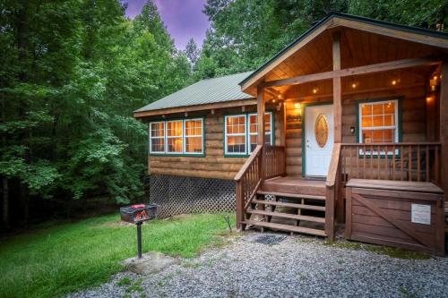 a log cabin with a porch and a grill at Cozy Cabin Retreat Near Helen Hot Tub Fireplace in Sautee Nacoochee
