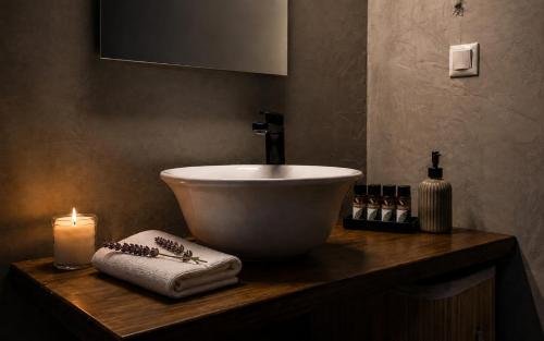 a bathroom with a sink and a candle on a counter at Romantic loft in Tríkala