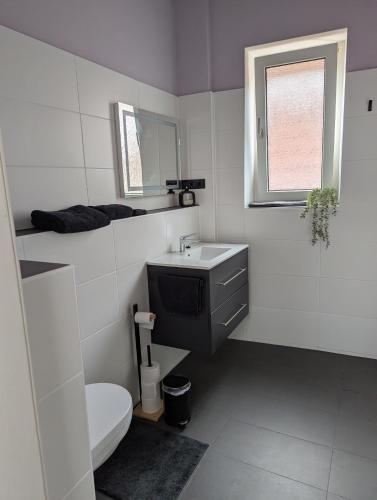 a white bathroom with a sink and a toilet at Ferienwohnung Altstadt Lemgo in Lemgo