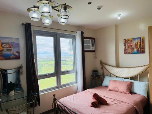 a bedroom with a bed and a large window at The Cozy Rustic in General Trias