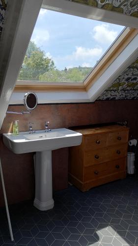 ein Badezimmer mit Waschbecken und Dachfenster in der Unterkunft Bear House B&B, Ensuite room above the Brachio Cafe, Colyton in Colyton
