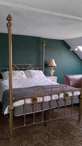 ein großes Bett in einem Schlafzimmer mit einer grünen Wand in der Unterkunft Bear House B&B, Ensuite room above the Brachio Cafe, Colyton in Colyton