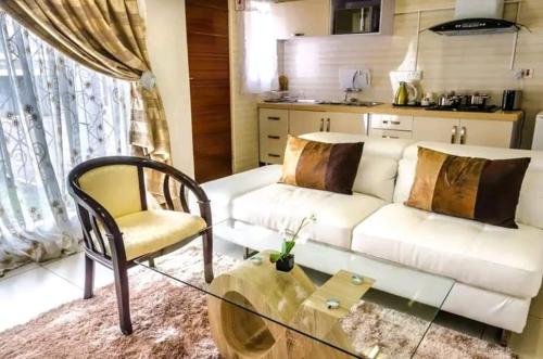 a living room with a white couch and a chair at Hillview inn hotel in Serowe