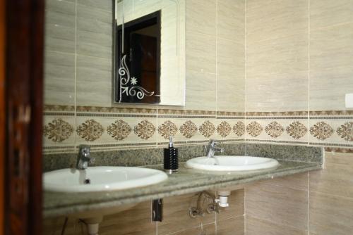 a bathroom with two sinks and a mirror at فندق شهرزاد - Shahrazad Hotel in Banī ‘Aţīyah