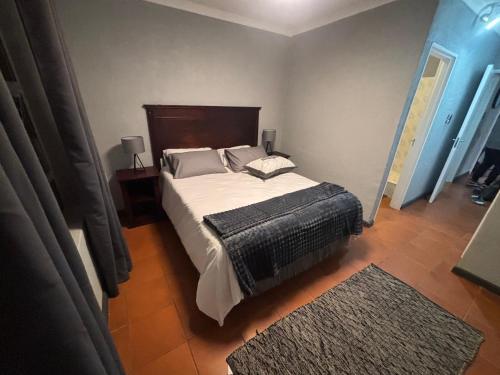 a bedroom with a large bed and a rug at Paradise Cove Marina in Jeffreys Bay