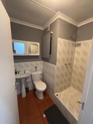 a bathroom with a toilet and a sink at Paradise Cove Marina in Jeffreys Bay
