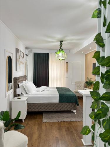a white bedroom with a bed and a window at Apartman Vanila Lux Kragujevac in Kragujevac