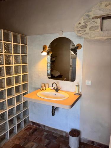 a bathroom with a sink and a mirror at Le Jardin Secret in Grignan