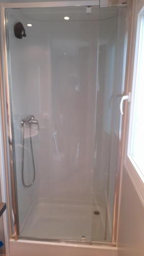 a shower with a glass door in a bathroom at Mobil Home AGDE Hérault in Agde
