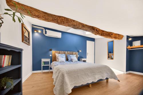 a bedroom with a blue wall and a bed at Pigeonnier de charme in Villefranche-de-Lauragais