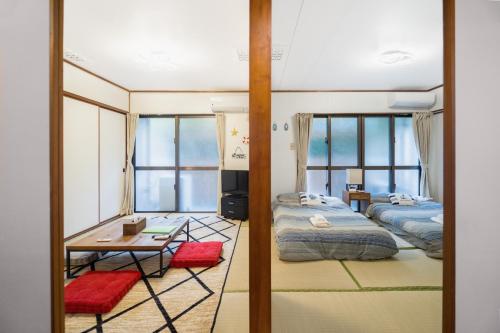 a room with two beds and a table in it at Green Hights Residence-107 in Naha