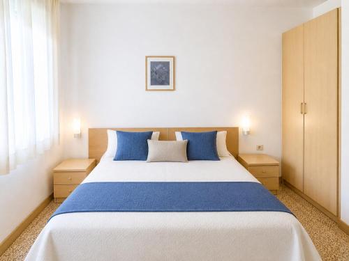 a bedroom with a large bed with blue pillows at Casa Francesca - Agenzia Cocal in Caorle