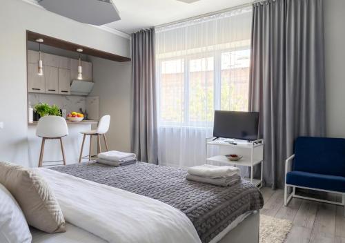 a bedroom with a bed and a tv and a blue chair at 40 m2 Confort apartament in Bălţi