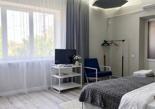 a bedroom with a bed and a tv and a chair at 40 m2 Confort apartament in Bălţi