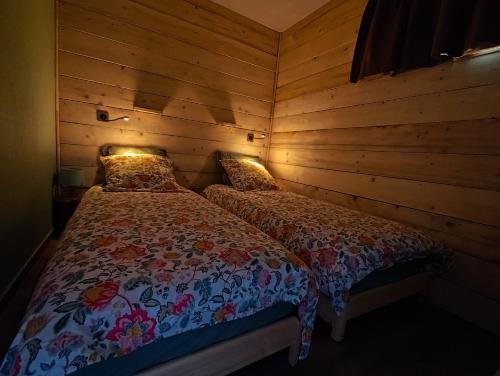 a bedroom with two beds in a room with wooden walls at Marla 52 in Le Dévoluy