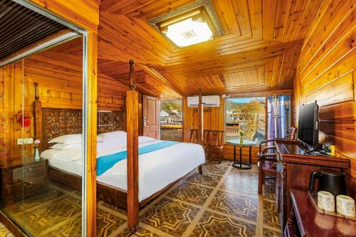 a bedroom with a bed and a television in a room at LQJ Riverside Guest House in Fenghuang County