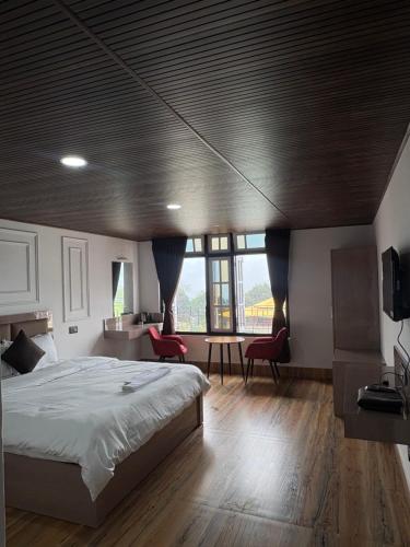 a bedroom with a bed and a table with chairs at Hotel khangyul in Ravangla
