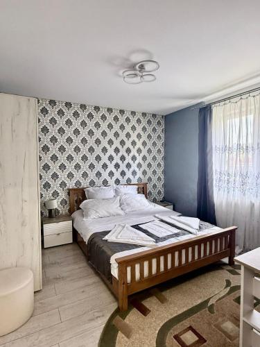 a bedroom with a bed with a blue wall at Cozy Urban Apartment in Câmpulung