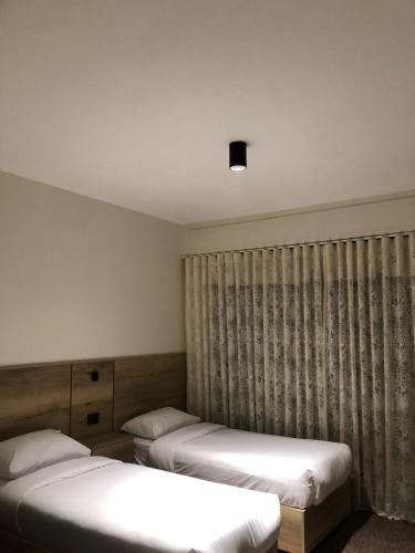 a room with two beds and a window with curtains at Alraha Resort in Aqaba