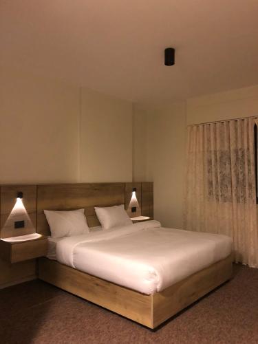 a bedroom with a large white bed with two lamps at Alraha Resort in Aqaba