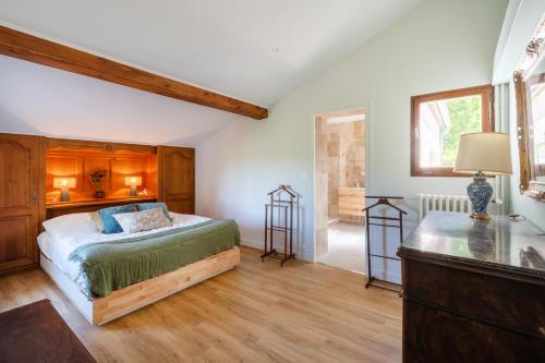 a bedroom with a bed and a desk in a room at Petit Clos d'Hélix in Annay-sur-Serein