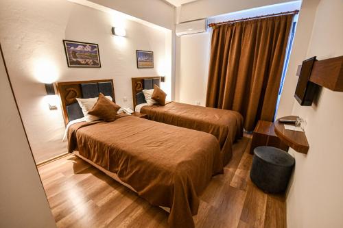 a hotel room with two beds and a mirror at Dorana Hotel in Kyrenia