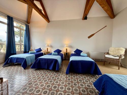 a room with three beds and a chair in it at La Belle Eclusière in Homps