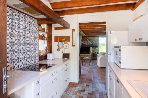 a kitchen with white cabinets and a tile floor at Petit Clos d'Hélix in Annay-sur-Serein