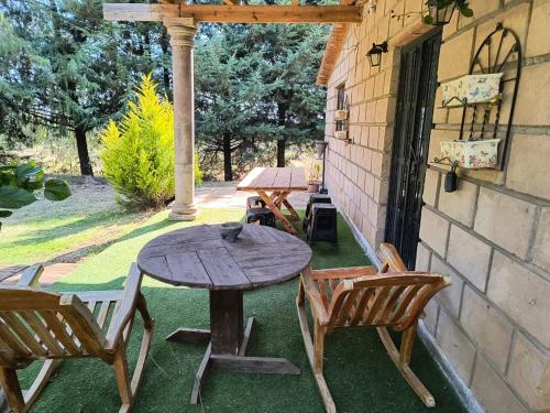a wooden table and chairs on a patio at Cabaña Metztli in Amealco