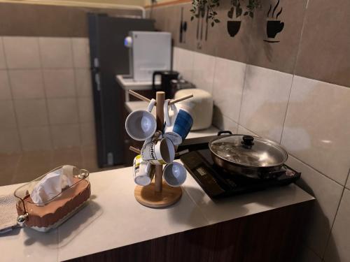 a kitchen counter with cups and a pan on a stove at klebang Beachfront Homestay I Snooker I Massage Chair I Pool in Malacca