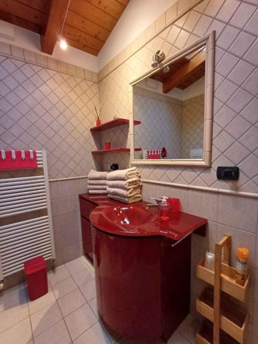 a bathroom with a red sink and a mirror at Casina Rossa in Ballabio