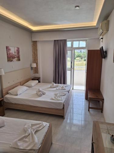 a hotel room with two beds and a balcony at Vera Studios in Faliraki