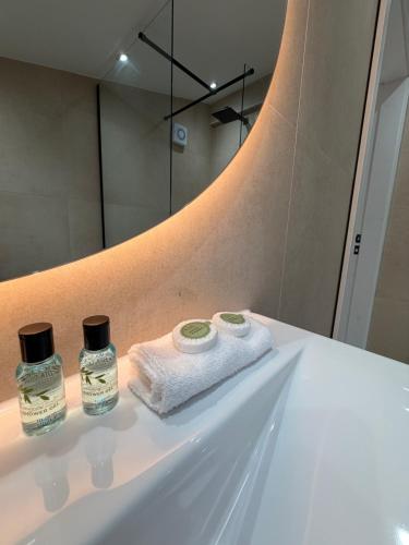 a bathroom sink with two towels and a mirror at Woodroyd Spa Suites in Luddenden Foot