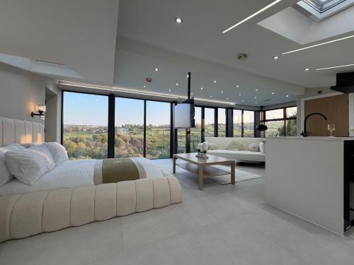 a white bedroom with a large bed and a table at Woodroyd Spa Suites in Luddenden Foot