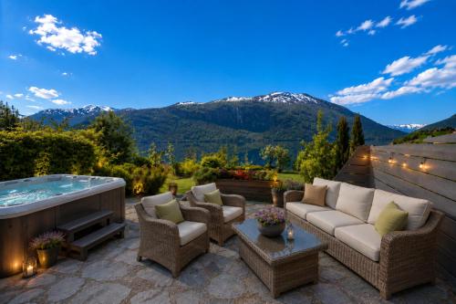 a patio with a hot tub and furniture and mountains at Villa Lilleheim in Breim