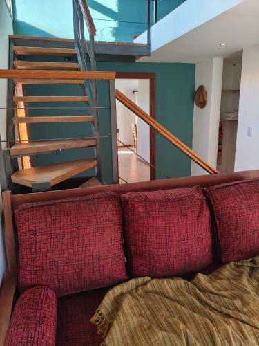 a couch with two red pillows in a living room at Camiare Aparts in Villa General Belgrano