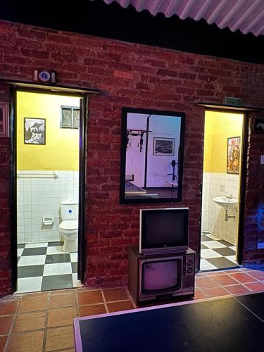 a living room with a tv and a bathroom at Escapada En La Quinta Esperanza in Sasaima
