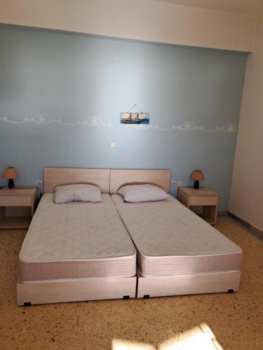 a large bed in a room with two tables at Pyrgis Glyfades studios in Glifades