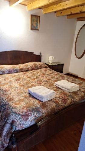 ein Schlafzimmer mit einem Bett und zwei Kissen darauf in der Unterkunft Casa Merei in Casa Poragine